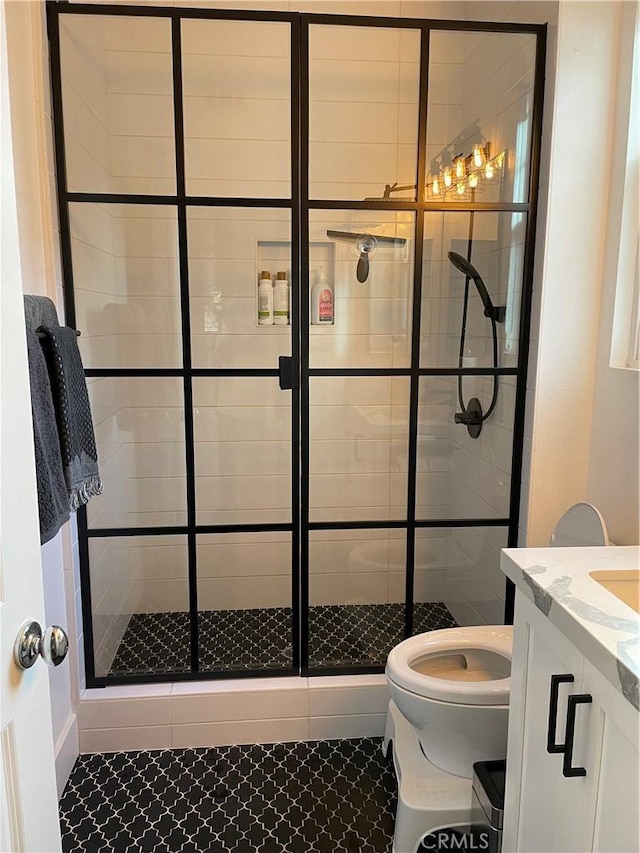 bathroom with a stall shower, vanity, and toilet