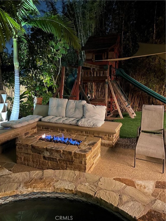 exterior space featuring an outdoor living space with a fire pit and a playground