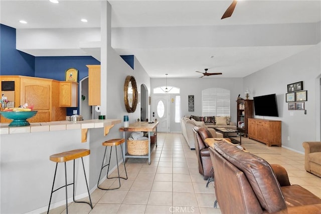 living room featuring a ceiling fan, arched walkways, light tile patterned flooring, and recessed lighting