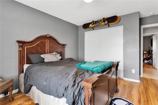 bedroom featuring a closet, baseboards, and wood finished floors