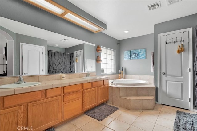 full bath with a garden tub, tile patterned flooring, and a sink