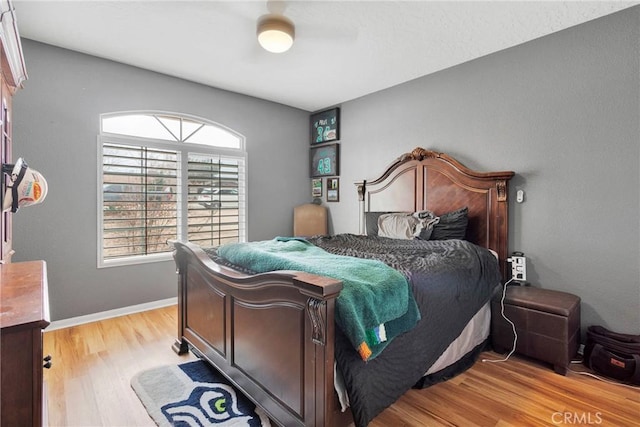 bedroom featuring light wood-style floors, baseboards, and a ceiling fan