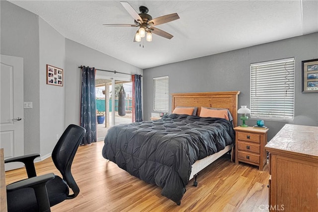 bedroom with ceiling fan, a textured ceiling, light wood-style flooring, access to exterior, and vaulted ceiling