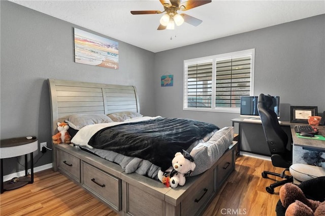 bedroom with baseboards, ceiling fan, and light wood-style floors