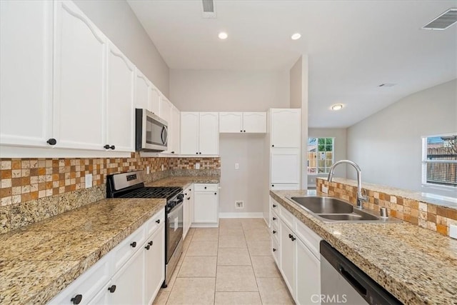 kitchen with light tile patterned floors, stainless steel appliances, a sink, visible vents, and white cabinetry