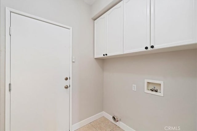 washroom featuring hookup for a washing machine, cabinet space, baseboards, and light tile patterned floors