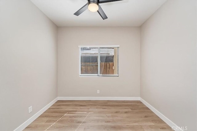 spare room featuring a ceiling fan, baseboards, and light wood finished floors