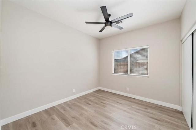 unfurnished bedroom with a ceiling fan, a closet, light wood finished floors, and baseboards