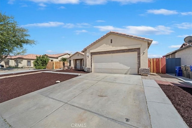 view of front facade featuring concrete driveway, an attached garage, fence, and stucco siding