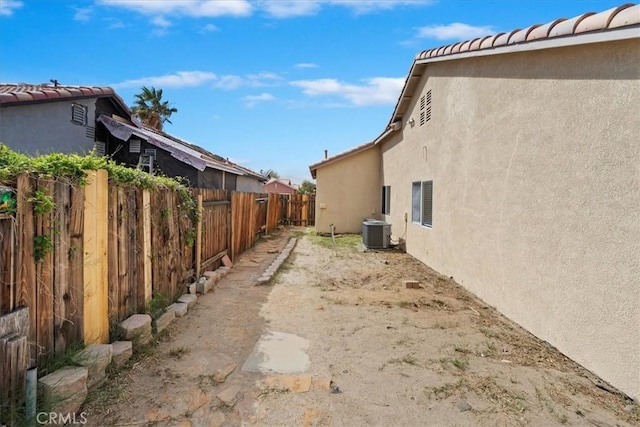 view of yard with fence and central AC unit