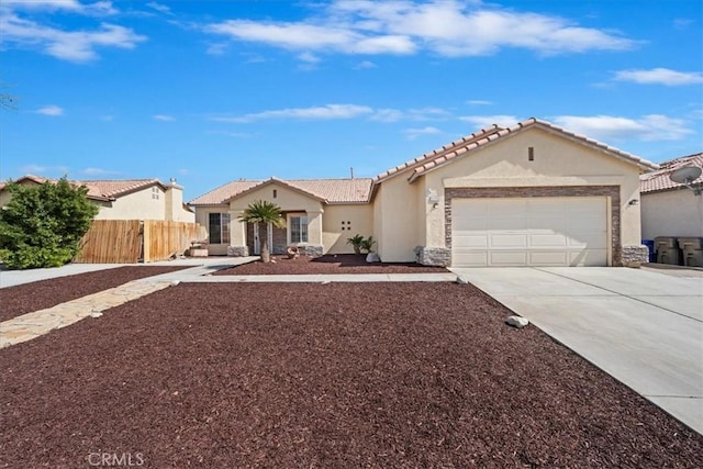 mediterranean / spanish house featuring a garage, fence, stone siding, driveway, and stucco siding