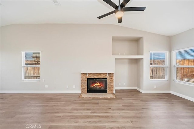 unfurnished living room with vaulted ceiling, baseboards, and wood finished floors