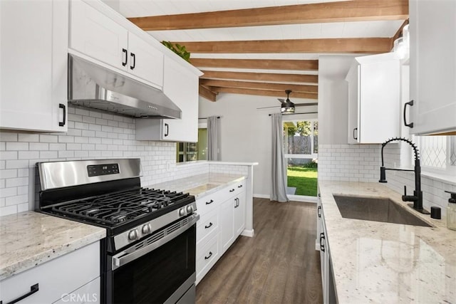 kitchen featuring vaulted ceiling with beams, gas stove, white cabinetry, a sink, and under cabinet range hood