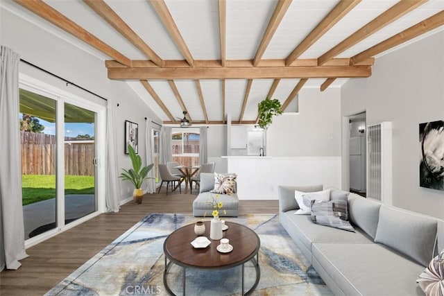 living room with a healthy amount of sunlight, vaulted ceiling with beams, and wood finished floors