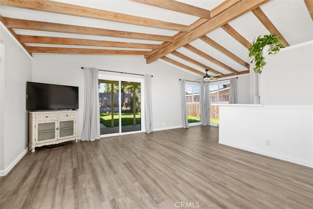 unfurnished living room with ceiling fan, lofted ceiling with beams, baseboards, and wood finished floors