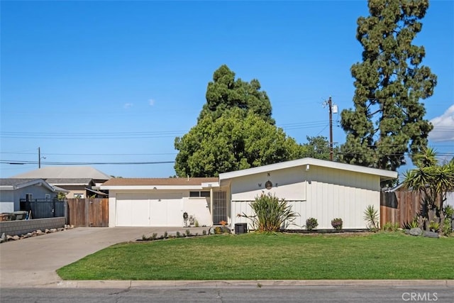 view of front of home with a garage, driveway, a front yard, and fence