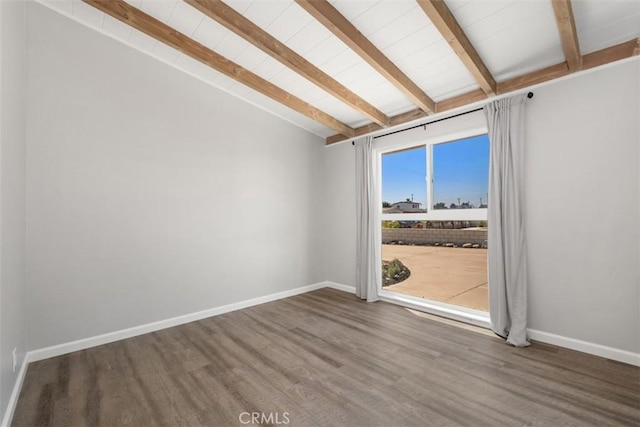 empty room featuring lofted ceiling with beams, baseboards, and wood finished floors