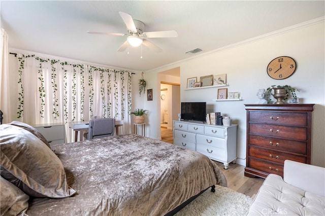 bedroom featuring a ceiling fan, visible vents, crown molding, and wood finished floors