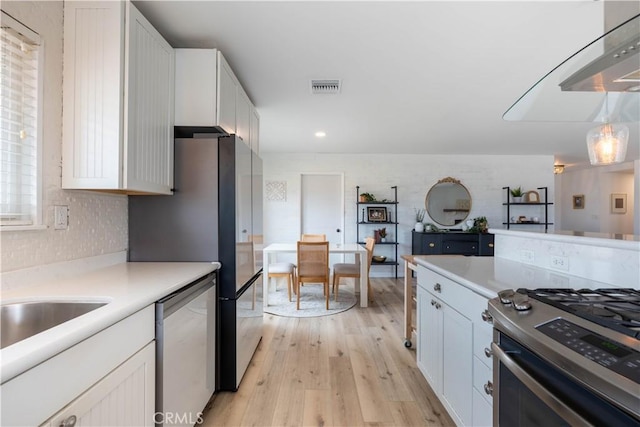 kitchen with light wood-style flooring, visible vents, stainless steel appliances, and light countertops