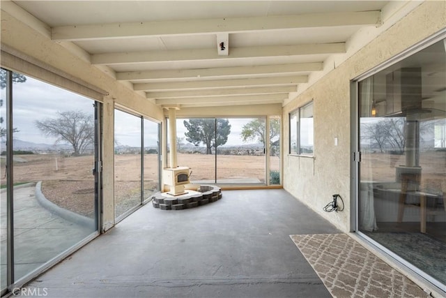 unfurnished sunroom with beam ceiling