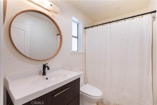 bathroom featuring toilet, a shower with shower curtain, and vanity