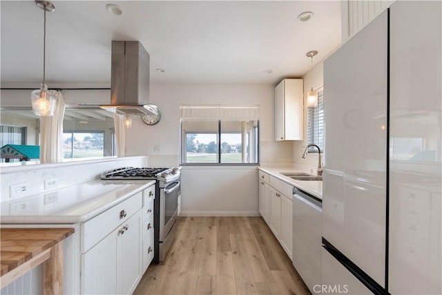 kitchen with dishwashing machine, island range hood, a sink, white cabinetry, and stainless steel gas stove