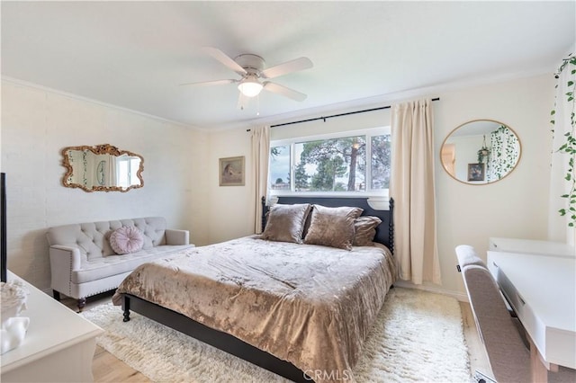 bedroom featuring ceiling fan, ornamental molding, and light wood-style flooring