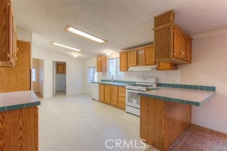 kitchen with brown cabinetry, white gas stove, under cabinet range hood, and a textured ceiling