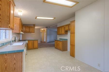 kitchen featuring brown cabinetry and a sink