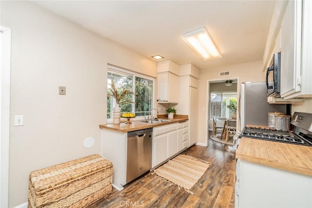 kitchen featuring a sink, visible vents, white cabinetry, and stainless steel appliances