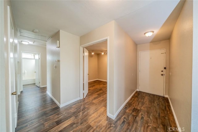 hallway with baseboards and dark wood-style flooring