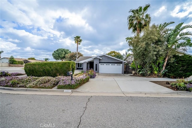 ranch-style home featuring stucco siding, an attached garage, and concrete driveway