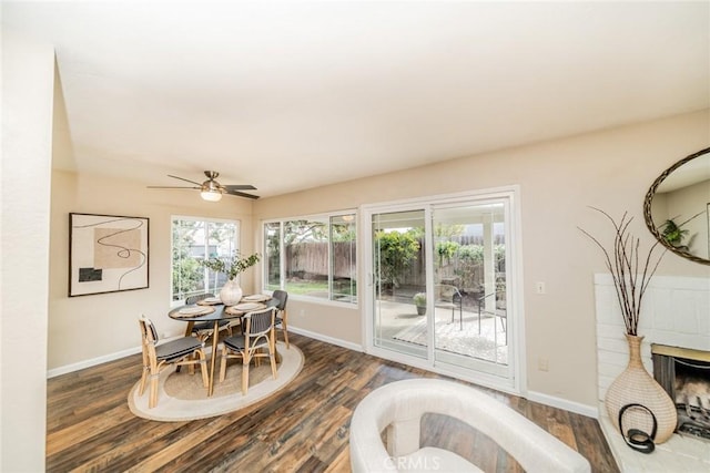 dining area featuring a ceiling fan, baseboards, and dark wood-style flooring