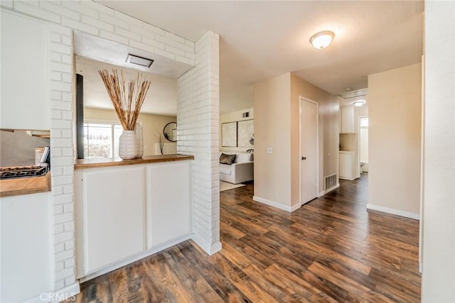 kitchen with wood finished floors, visible vents, wooden counters, and baseboards