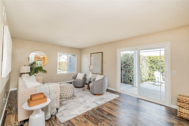 sitting room with baseboards and dark wood-style flooring