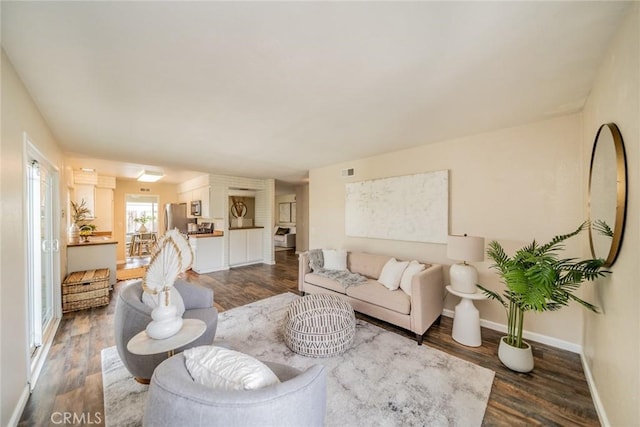 living area with visible vents, baseboards, and dark wood-type flooring