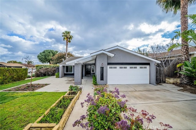 view of front of property with stucco siding, a vegetable garden, concrete driveway, a front yard, and a garage