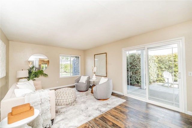 living area with baseboards and wood finished floors