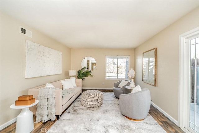 living room with visible vents, baseboards, and wood finished floors