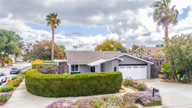 ranch-style house with an attached garage, driveway, and stucco siding