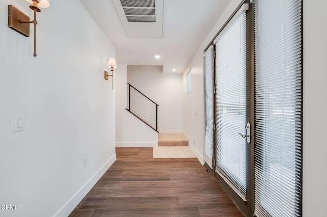 hallway featuring visible vents, baseboards, wood finished floors, stairs, and recessed lighting