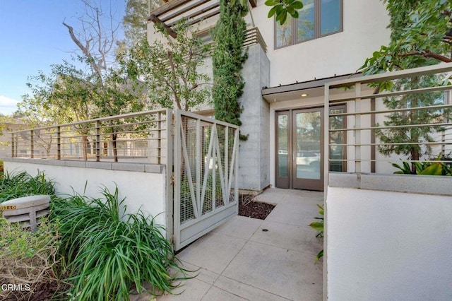 view of exterior entry with a patio and stucco siding