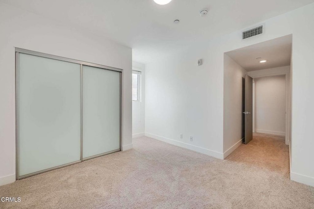 unfurnished bedroom with recessed lighting, a closet, visible vents, carpet flooring, and baseboards