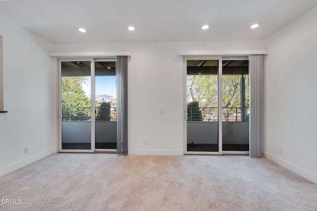 carpeted spare room featuring baseboards, plenty of natural light, and recessed lighting