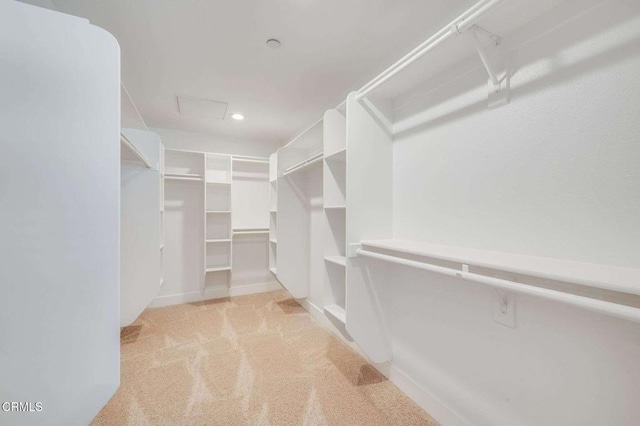 spacious closet with attic access and light carpet