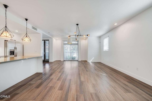 unfurnished living room with baseboards, dark wood finished floors, and visible vents