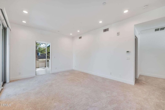 spare room with baseboards, light carpet, recessed lighting, and visible vents