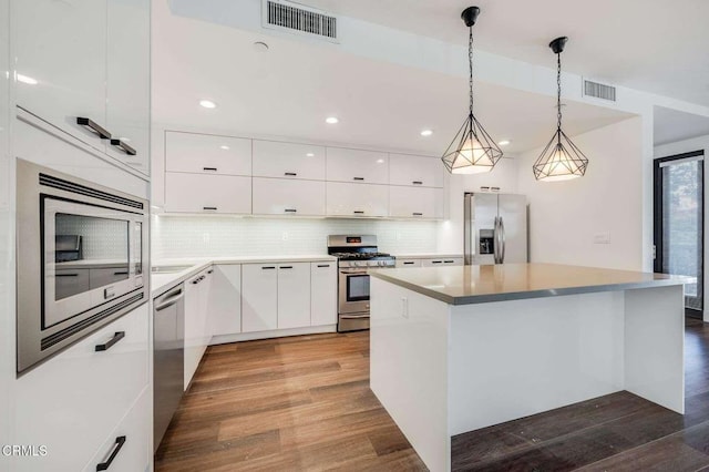 kitchen with white cabinets, appliances with stainless steel finishes, visible vents, and dark wood-type flooring