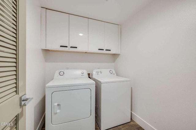 washroom featuring baseboards, cabinet space, and washer and dryer