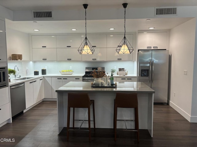 239 S Marengo Ave Unit 112, Pasadena, CA 91101 - kitchen with appliances with stainless steel finishes, modern cabinets, a kitchen bar, white cabinets, and recessed lighting
